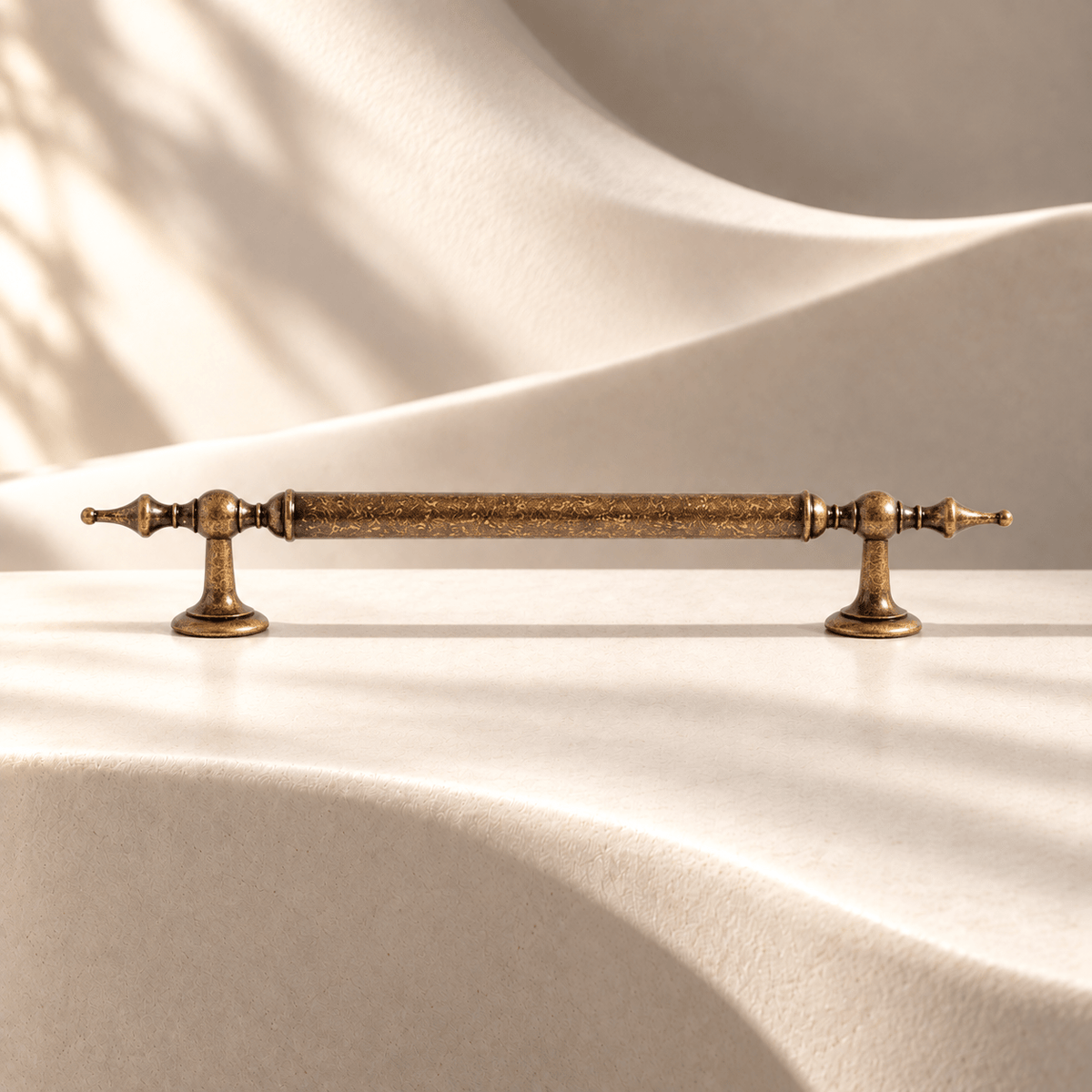 Aged antique brass cabinet pull — 160 mm on warm ivory stone