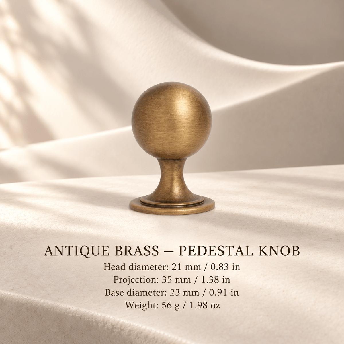 Antique brass pedestal knob in ivory studio. Head diameter: 21 mm / 0.83 in; Projection: 35 mm / 1.38 in; Base diameter: 23 mm / 0.91 in; Weight: 56 g / 1.98 oz.
