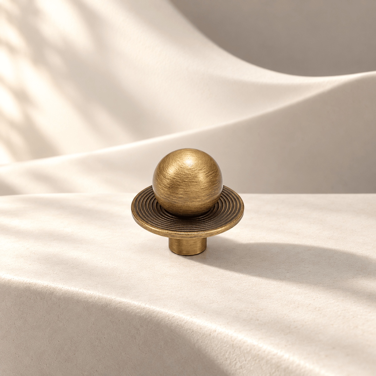 Antique bronze brass ball knob with concentric-ring plate on warm ivory stone