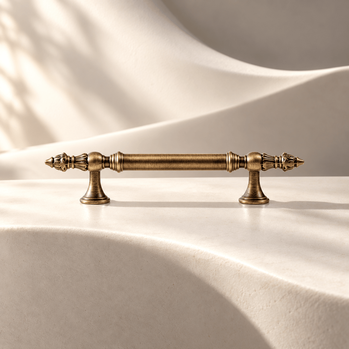 Classic antique bronze cabinet pull — 96 mm on warm ivory stone