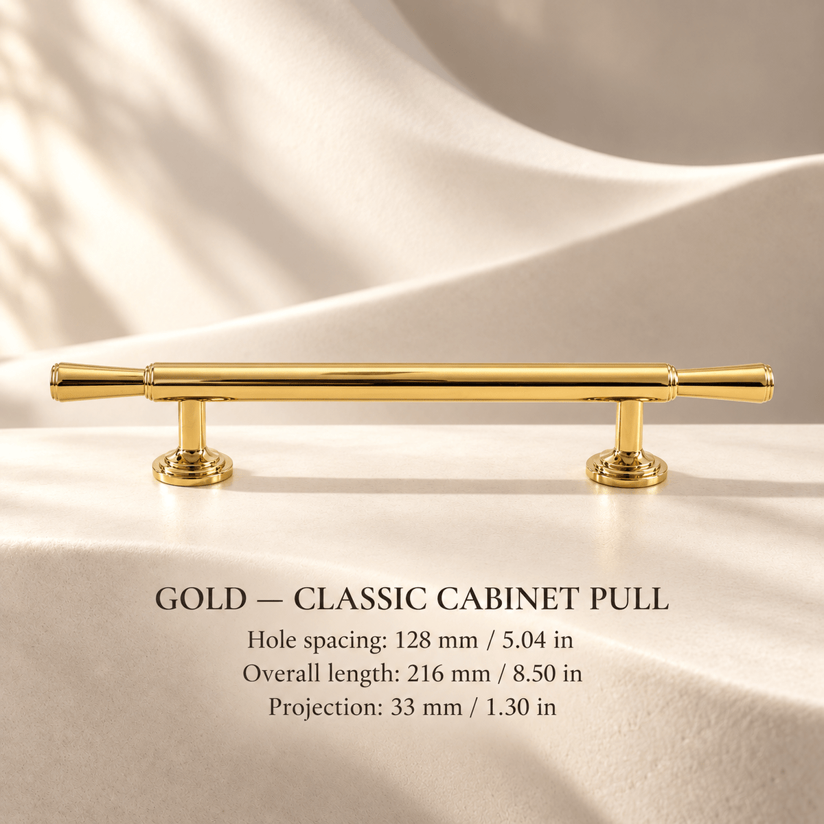 Polished gold classic cabinet pull in ivory studio. Hole spacing: 128 mm / 5.04 in; Overall length: 216 mm / 8.50 in; Projection: 33 mm / 1.30 in