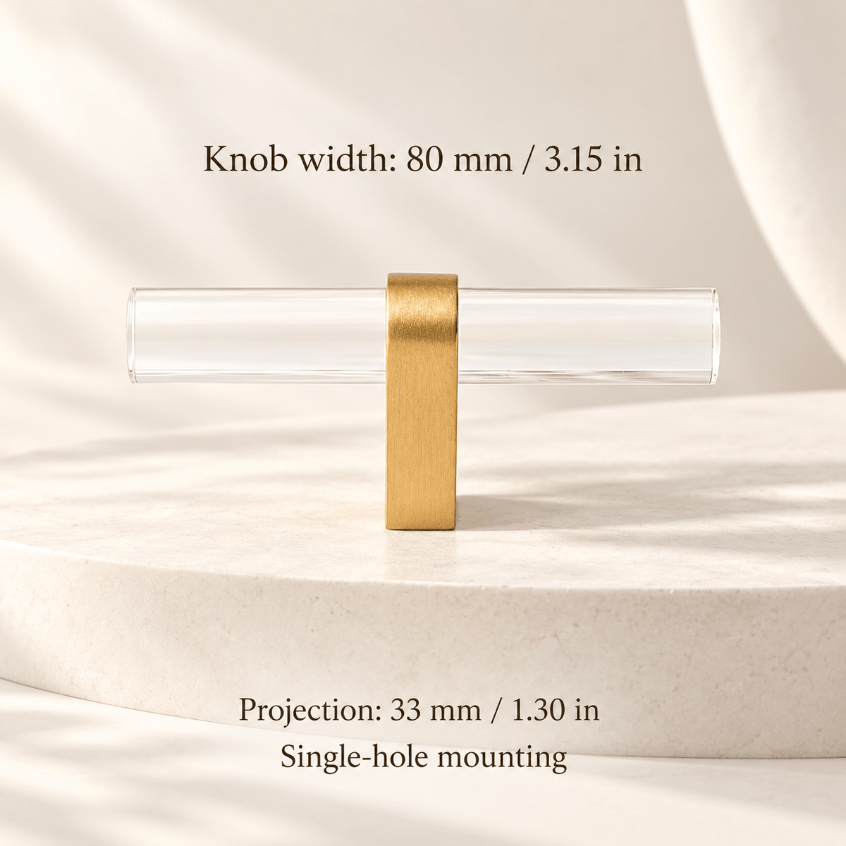 Clear acrylic T-knob with gold foot in ivory studio. Knob width: 80 mm / 3.15 in; Projection: 33 mm / 1.30 in; Single-hole mounting