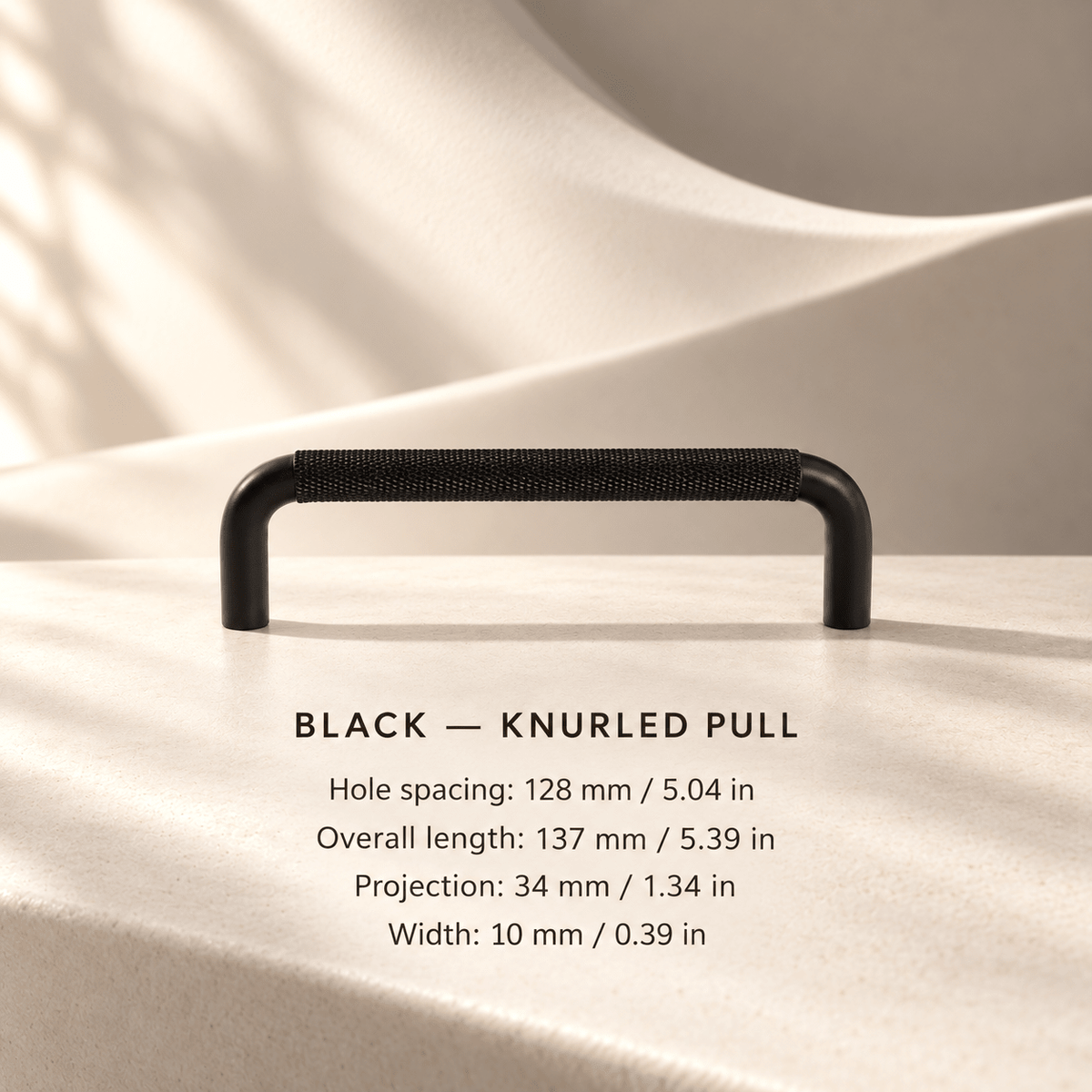 Black knurled cabinet pull in ivory studio. Hole spacing: 128 mm / 5.04 in; Overall length: 137 mm / 5.39 in; Projection: 34 mm / 1.34 in; Width: 10 mm / 0.39 in