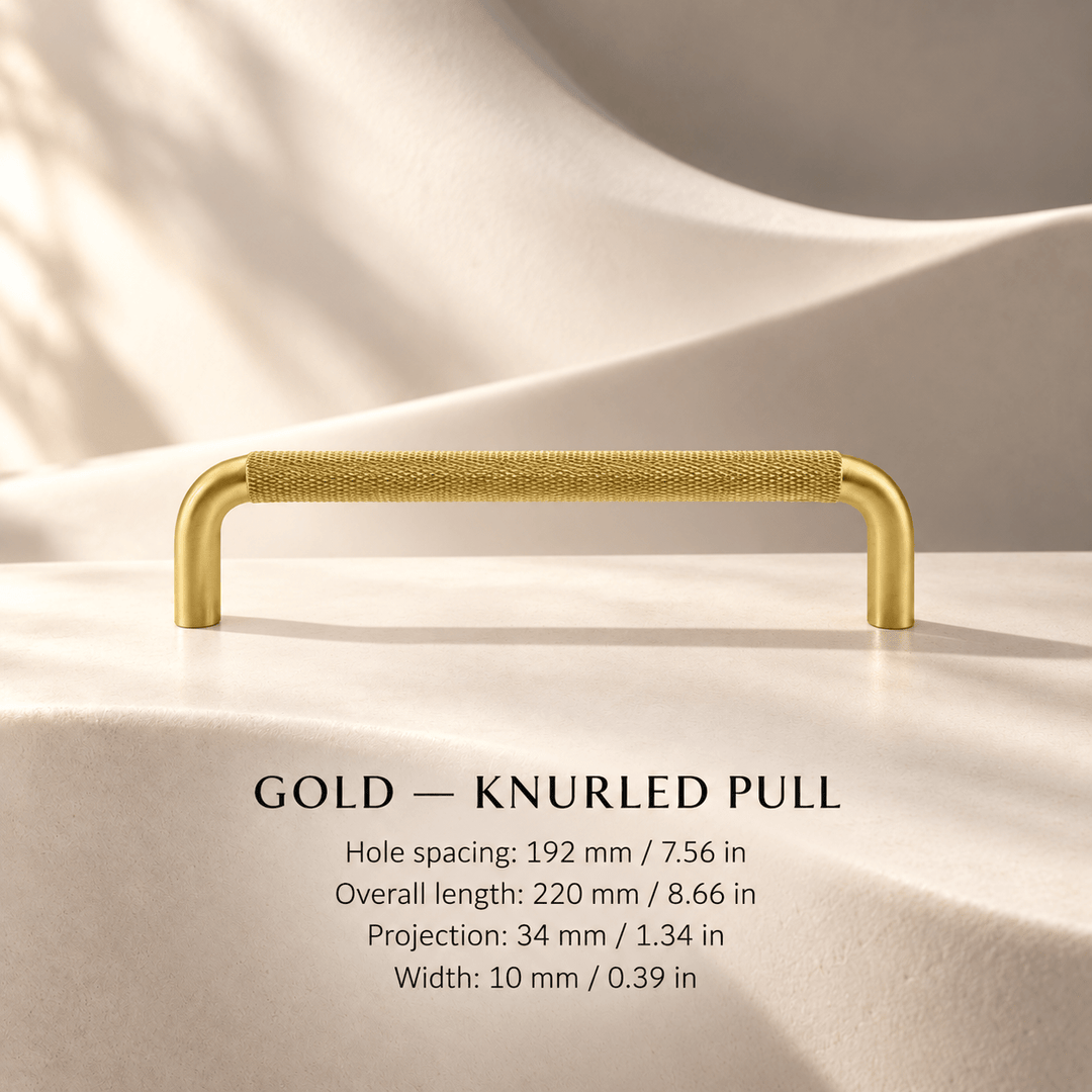 Gold knurled cabinet pull in ivory studio. Hole spacing: 192 mm / 7.56 in; Overall length: 220 mm / 8.66 in; Projection: 34 mm / 1.34 in; Width: 10 mm / 0.39 in