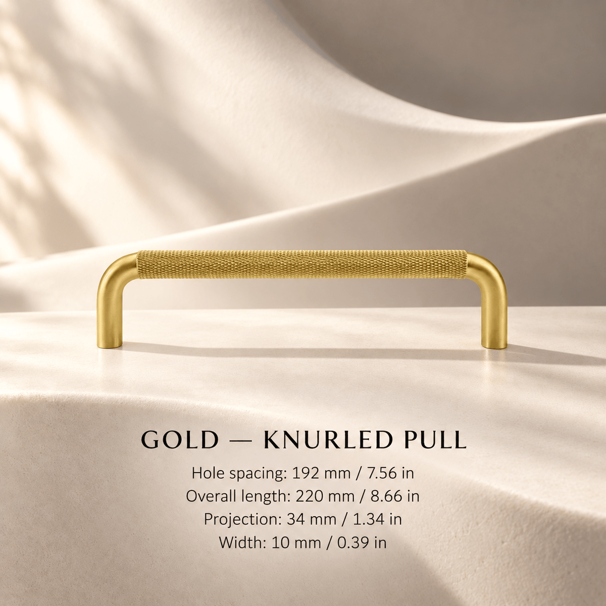 Gold knurled cabinet pull in ivory studio. Hole spacing: 192 mm / 7.56 in; Overall length: 220 mm / 8.66 in; Projection: 34 mm / 1.34 in; Width: 10 mm / 0.39 in
