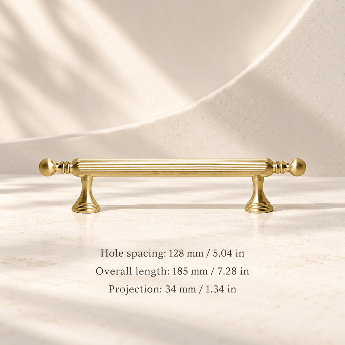 Gold fluted ball-finial cabinet hardware in ivory studio. Hole spacing: 128 mm / 5.04 in; Overall length: 185 mm / 7.28 in; Projection: 34 mm / 1.34 in