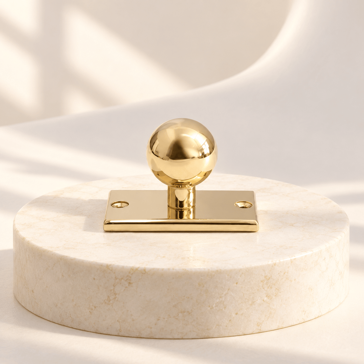 Polished gold brass ball cabinet knob with rectangular backplate, ivory stone studio