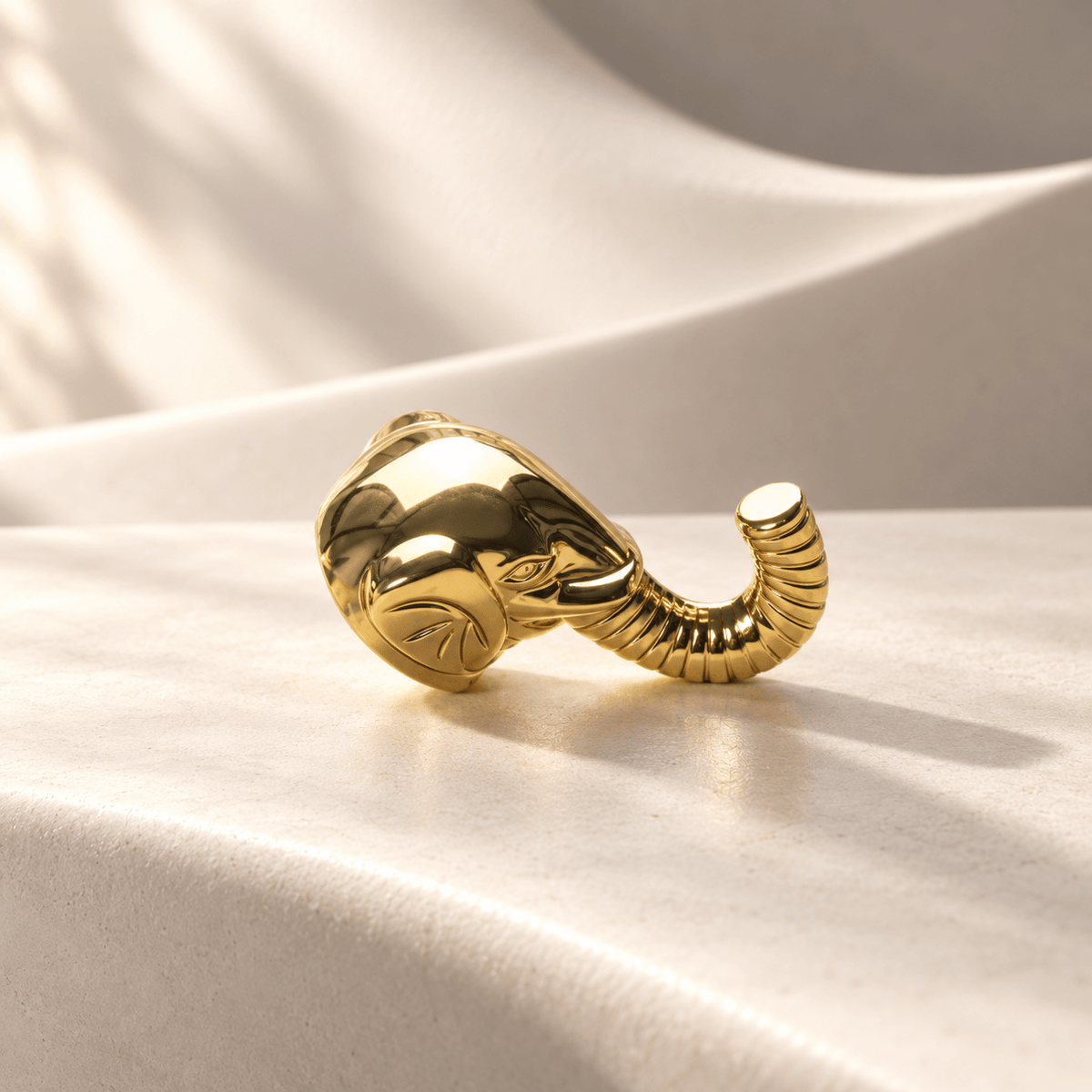 Gold elephant-head cabinet knob or hook, warm ivory stone studio