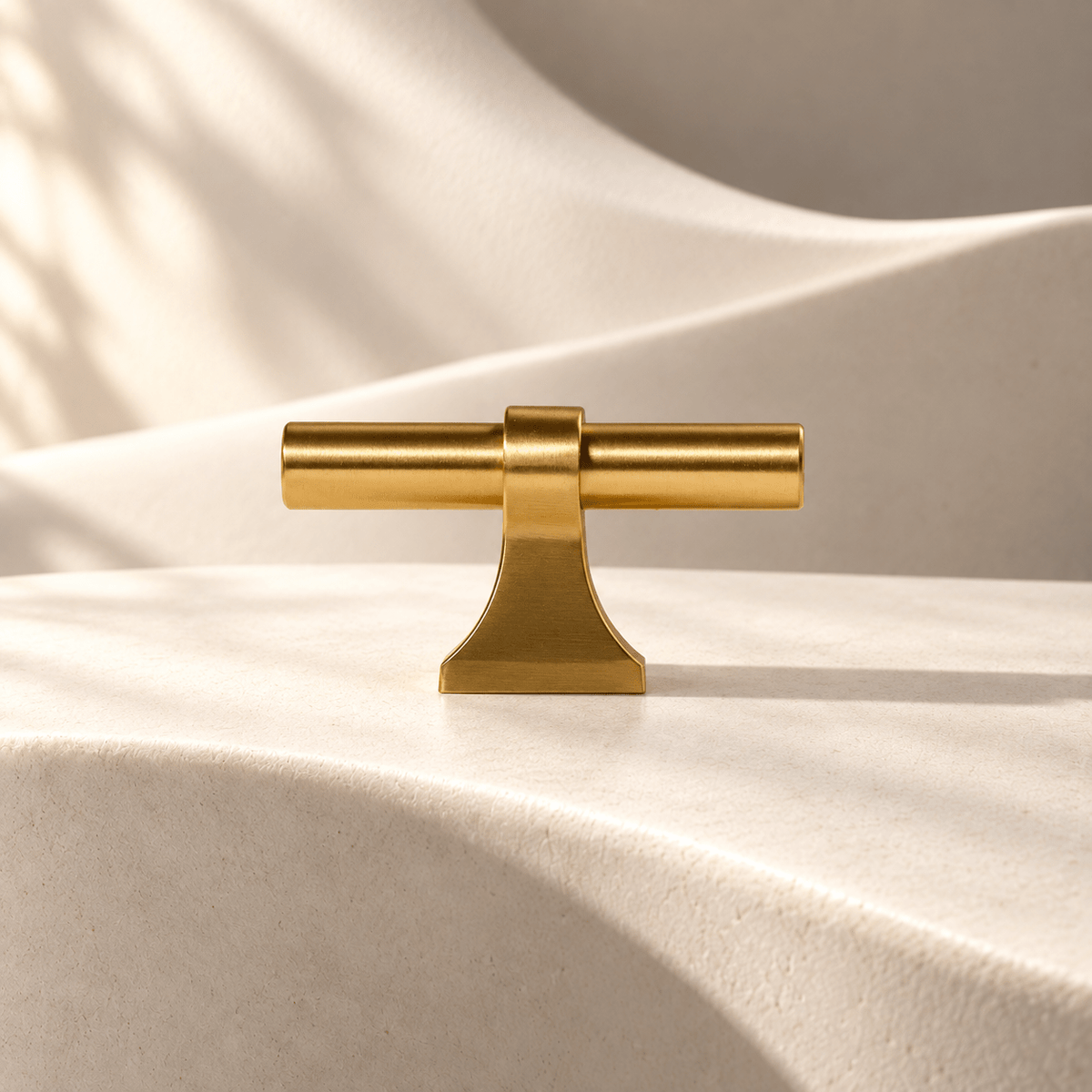 Gold flared-foot T-bar knob — warm ivory studio
