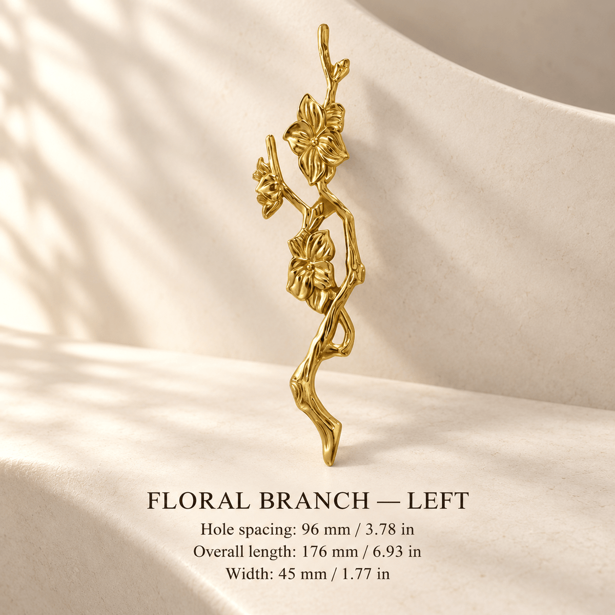 Gold floral branch cabinet pull, left, in ivory studio. Hole spacing: 96 mm / 3.78 in; Overall length: 176 mm / 6.93 in; Width: 45 mm / 1.77 in