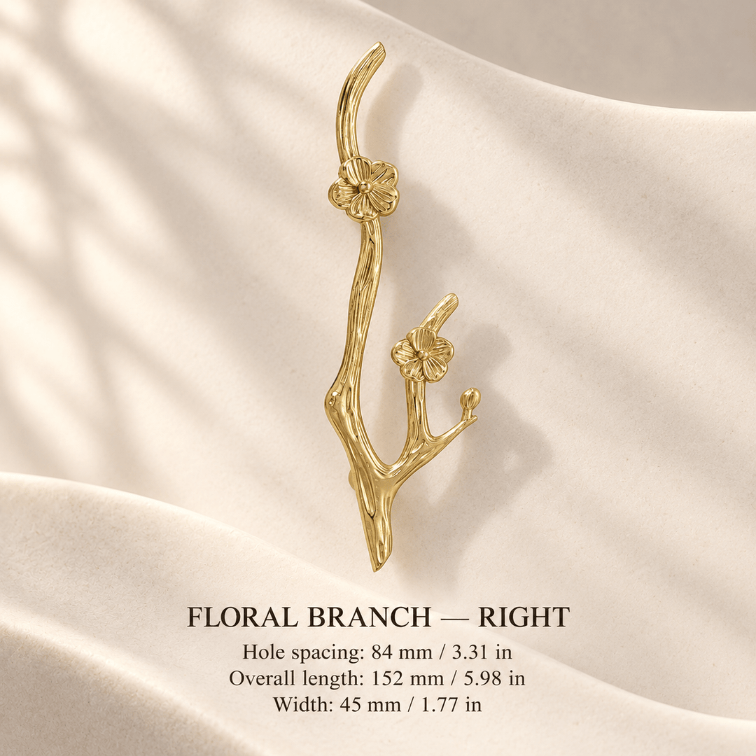 Gold floral branch cabinet pull, right, in ivory studio. Hole spacing: 84 mm / 3.31 in; Overall length: 152 mm / 5.98 in; Width: 45 mm / 1.77 in