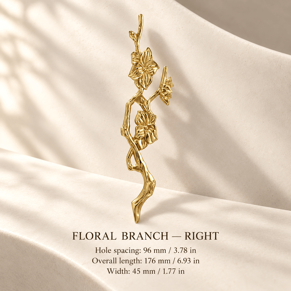 Gold floral branch cabinet pull, right, in ivory studio. Hole spacing: 96 mm / 3.78 in; Overall length: 176 mm / 6.93 in; Width: 45 mm / 1.77 in