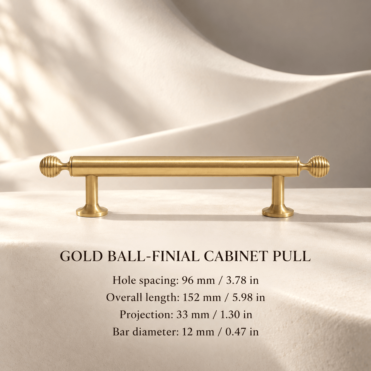 Gold ball-finial cabinet pull, 96 mm hole spacing, individual millimeter and inch measurements in an ivory studio