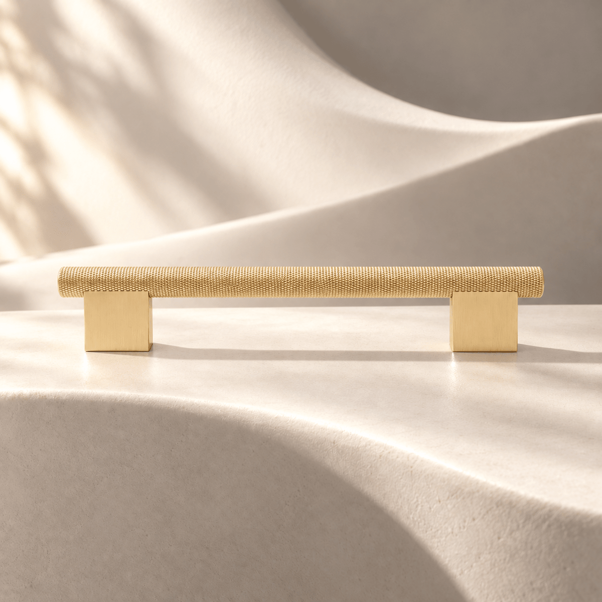 Satin gold knurled cabinet pull, 128 mm hole spacing on ivory stone