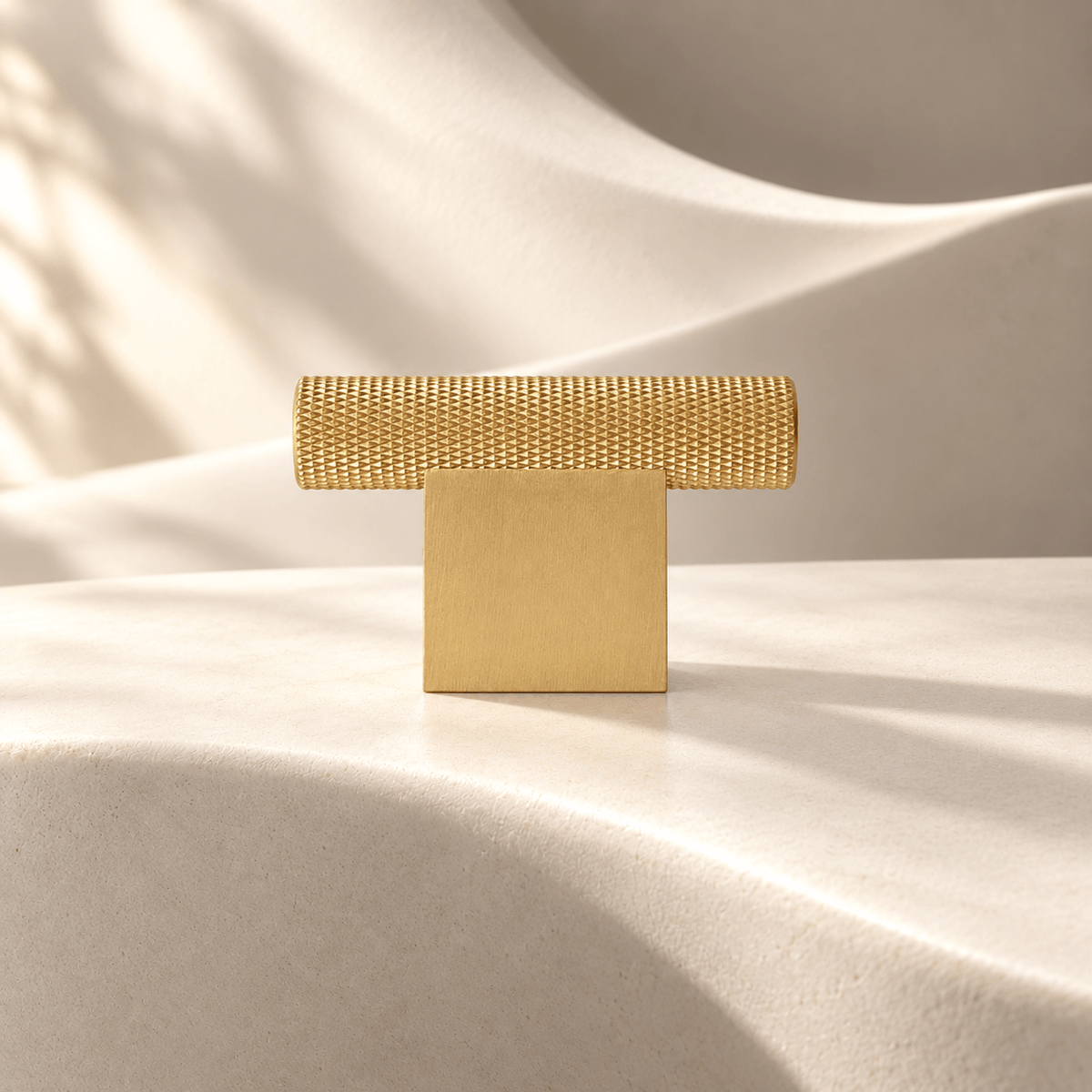Satin gold knurled T-knob, 54 mm overall width on ivory stone
