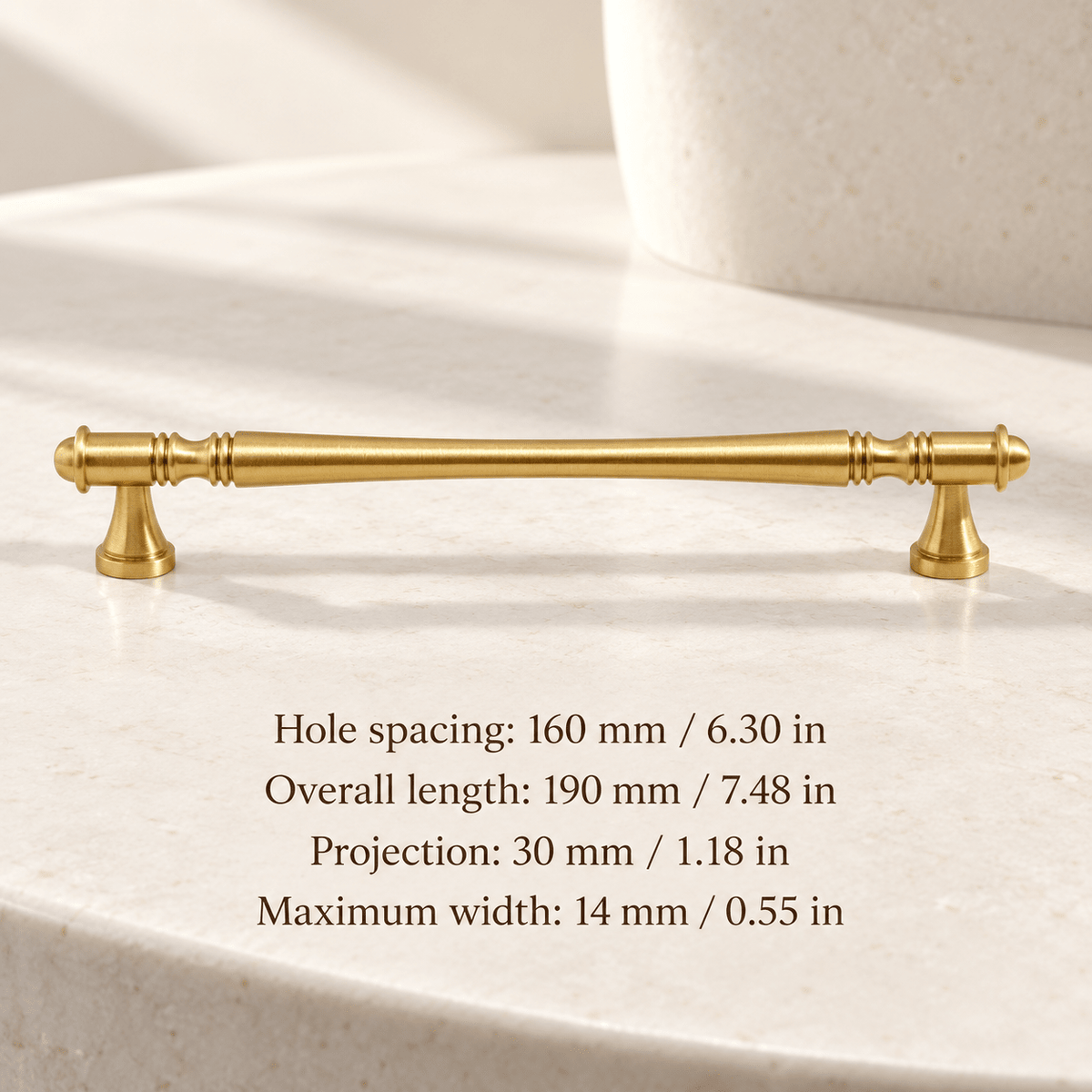 Gold waisted spindle cabinet pull in ivory studio. Hole spacing: 160 mm / 6.30 in; Overall length: 190 mm / 7.48 in; Projection: 30 mm / 1.18 in; Maximum width: 14 mm / 0.55 in