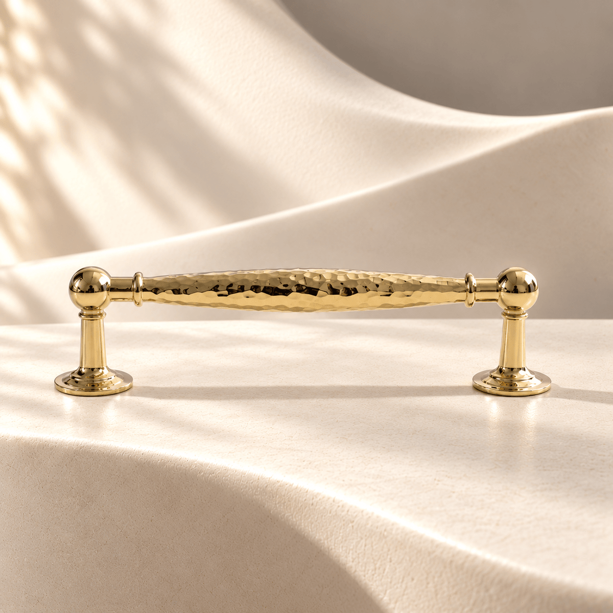 Polished gold hammered cabinet pull — 128 mm CTC on warm ivory stone