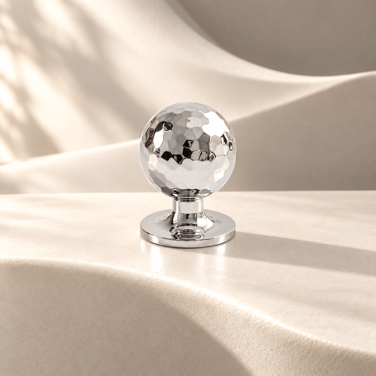 Hammered chrome ball cabinet knob on warm ivory stone