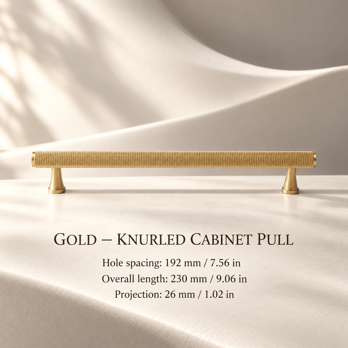 Gold knurled cabinet pull with flared feet in ivory studio. Hole spacing: 192 mm / 7.56 in; Overall length: 230 mm / 9.06 in; Projection: 26 mm / 1.02 in