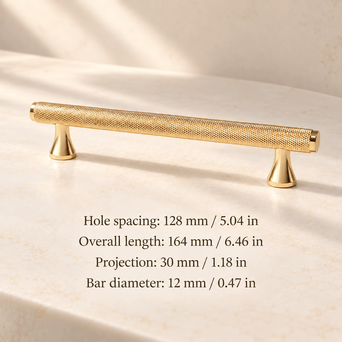 Gold knurled cabinet pull with flared feet in ivory studio. Hole spacing: 128 mm / 5.04 in; Overall length: 164 mm / 6.46 in; Projection: 30 mm / 1.18 in; Bar diameter: 12 mm / 0.47 in