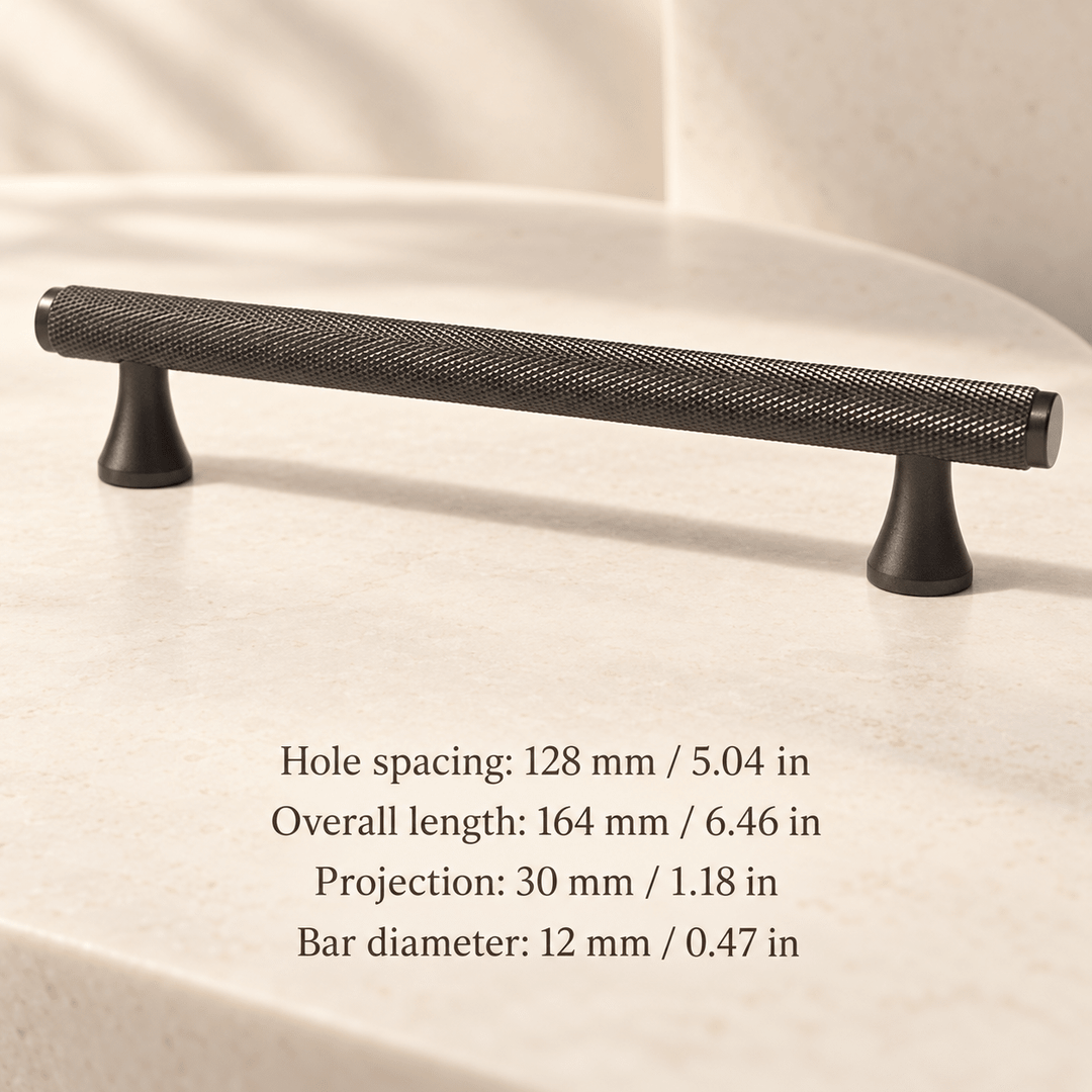Grey knurled cabinet pull with flared feet in ivory studio. Hole spacing: 128 mm / 5.04 in; Overall length: 164 mm / 6.46 in; Projection: 30 mm / 1.18 in; Bar diameter: 12 mm / 0.47 in
