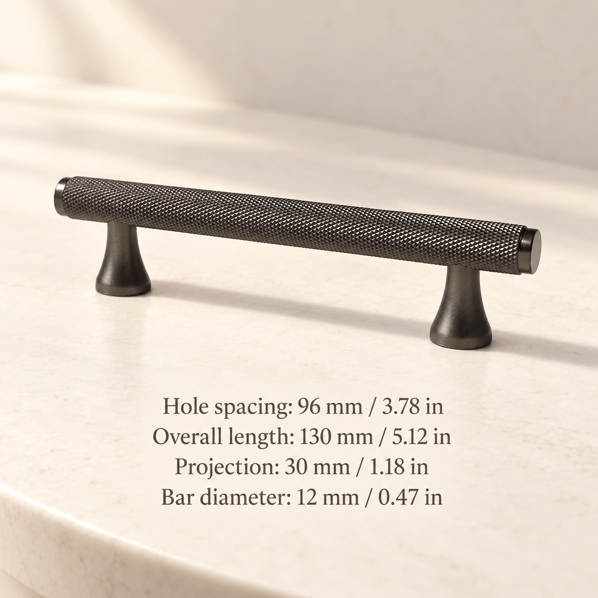 Grey knurled cabinet pull with flared feet in ivory studio. Hole spacing: 96 mm / 3.78 in; Overall length: 130 mm / 5.12 in; Projection: 30 mm / 1.18 in; Bar diameter: 12 mm / 0.47 in