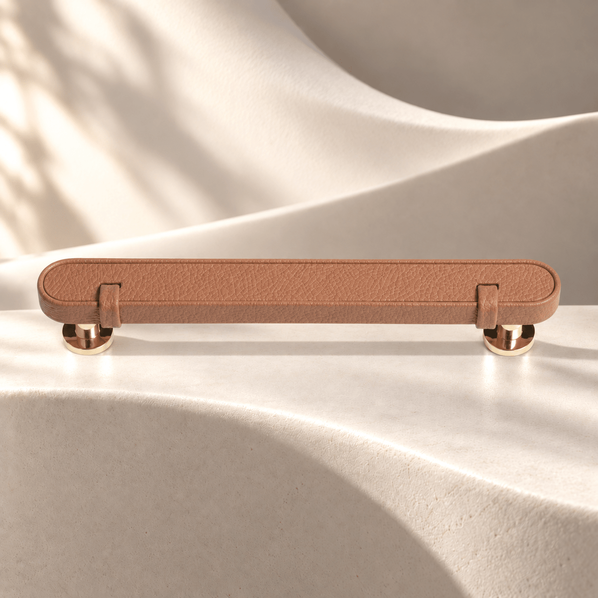 Tan — 128 mm CTC leather cabinet pull on warm ivory stone