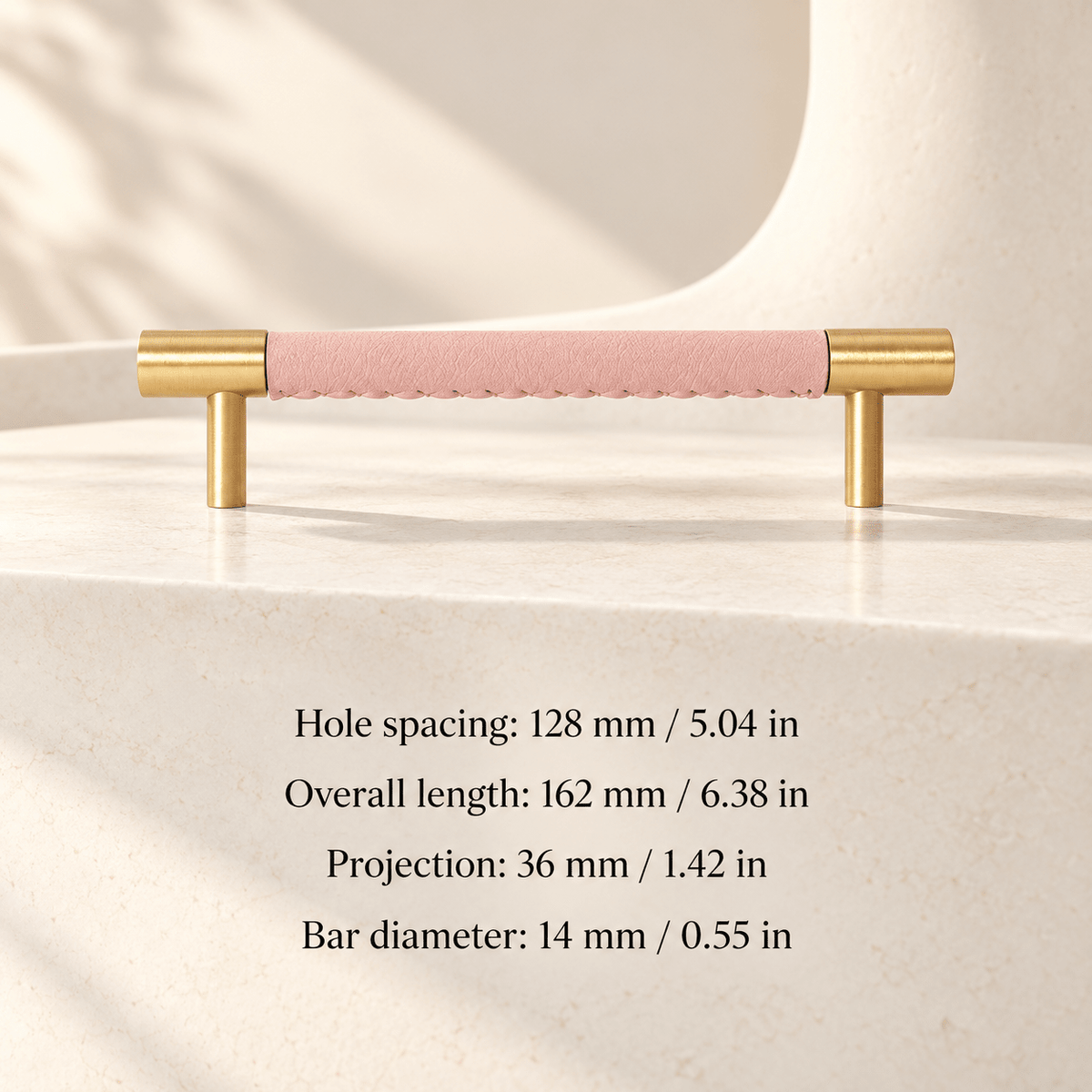 pink leather cabinet pull with gold ends in ivory studio. Hole spacing: 128 mm / 5.04 in; Overall length: 162 mm / 6.38 in; Projection: 36 mm / 1.42 in; Bar diameter: 14 mm / 0.55 in