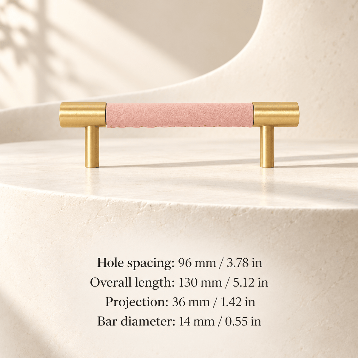 pink leather cabinet pull with gold ends in ivory studio. Hole spacing: 96 mm / 3.78 in; Overall length: 130 mm / 5.12 in; Projection: 36 mm / 1.42 in; Bar diameter: 14 mm / 0.55 in