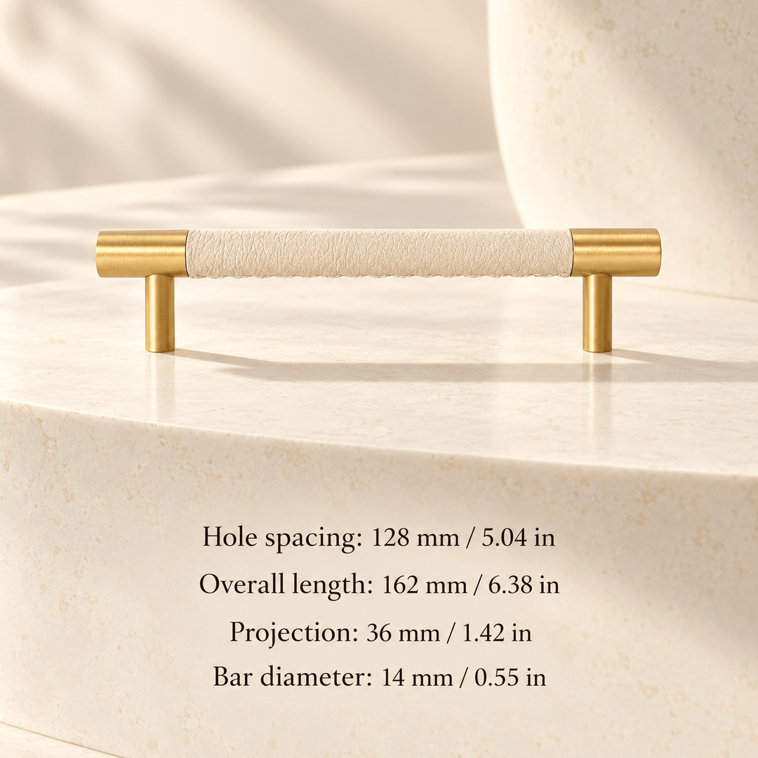 ivory white leather cabinet pull with gold ends in ivory studio. Hole spacing: 128 mm / 5.04 in; Overall length: 162 mm / 6.38 in; Projection: 36 mm / 1.42 in; Bar diameter: 14 mm / 0.55 in