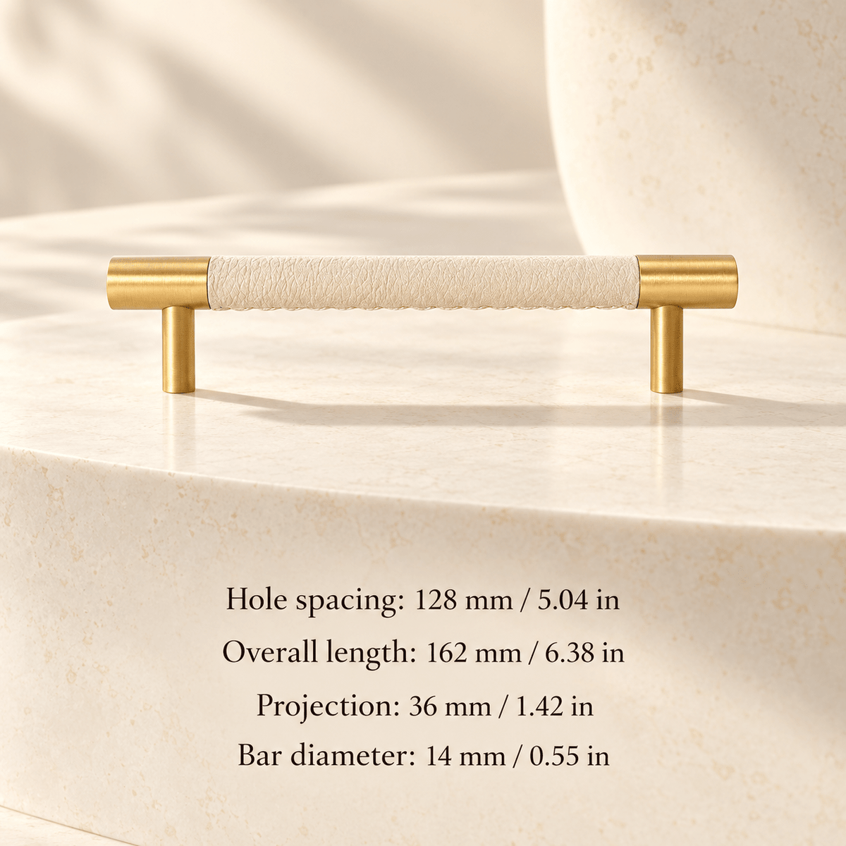 ivory white leather cabinet pull with gold ends in ivory studio. Hole spacing: 128 mm / 5.04 in; Overall length: 162 mm / 6.38 in; Projection: 36 mm / 1.42 in; Bar diameter: 14 mm / 0.55 in