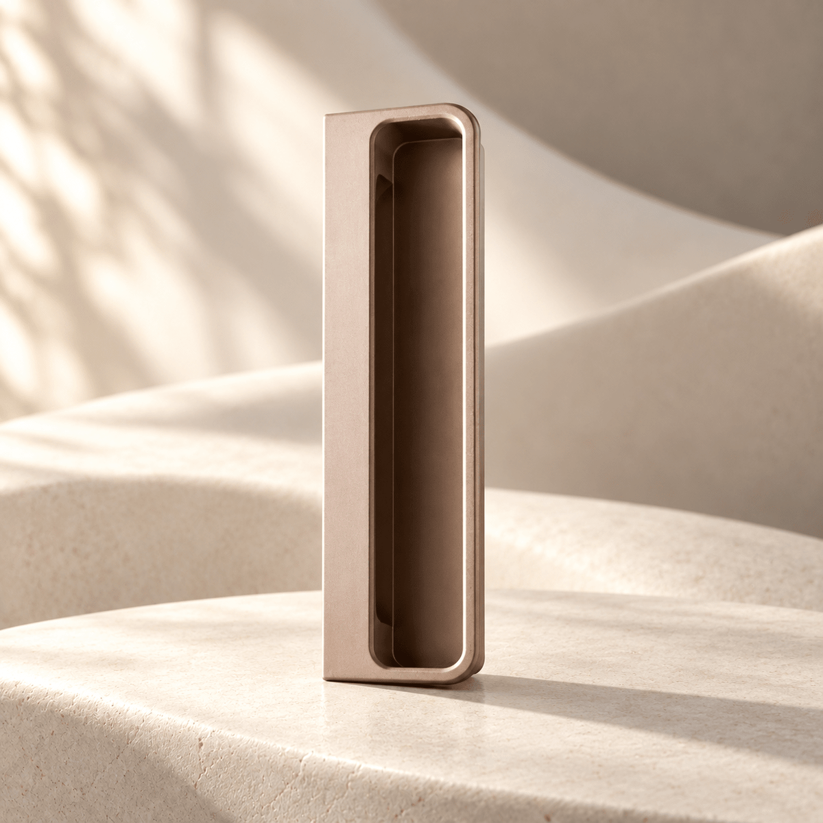 Light brown recessed cabinet handle on warm ivory stone