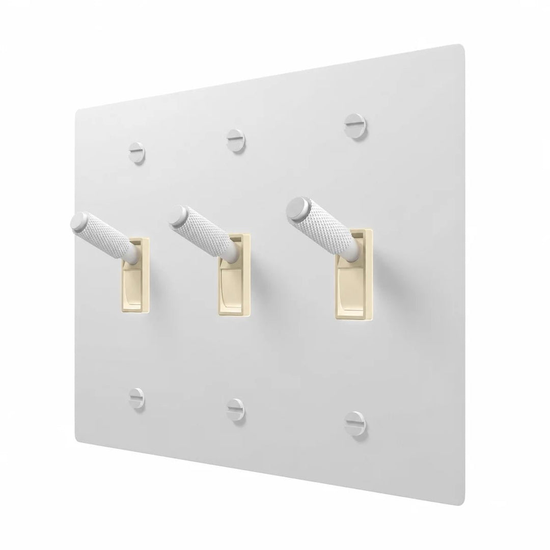 PlatePrestige Brass Toggle Switch 3-Gang in All-White with ivory toggle frames, angled view