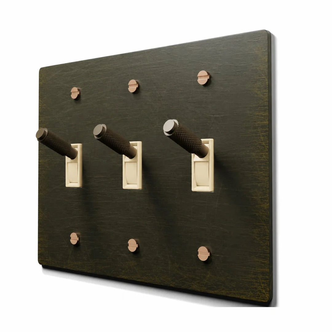 PlatePrestige Brass Toggle Switch 3-Gang in Antique Brass with ivory toggle frames, angled view