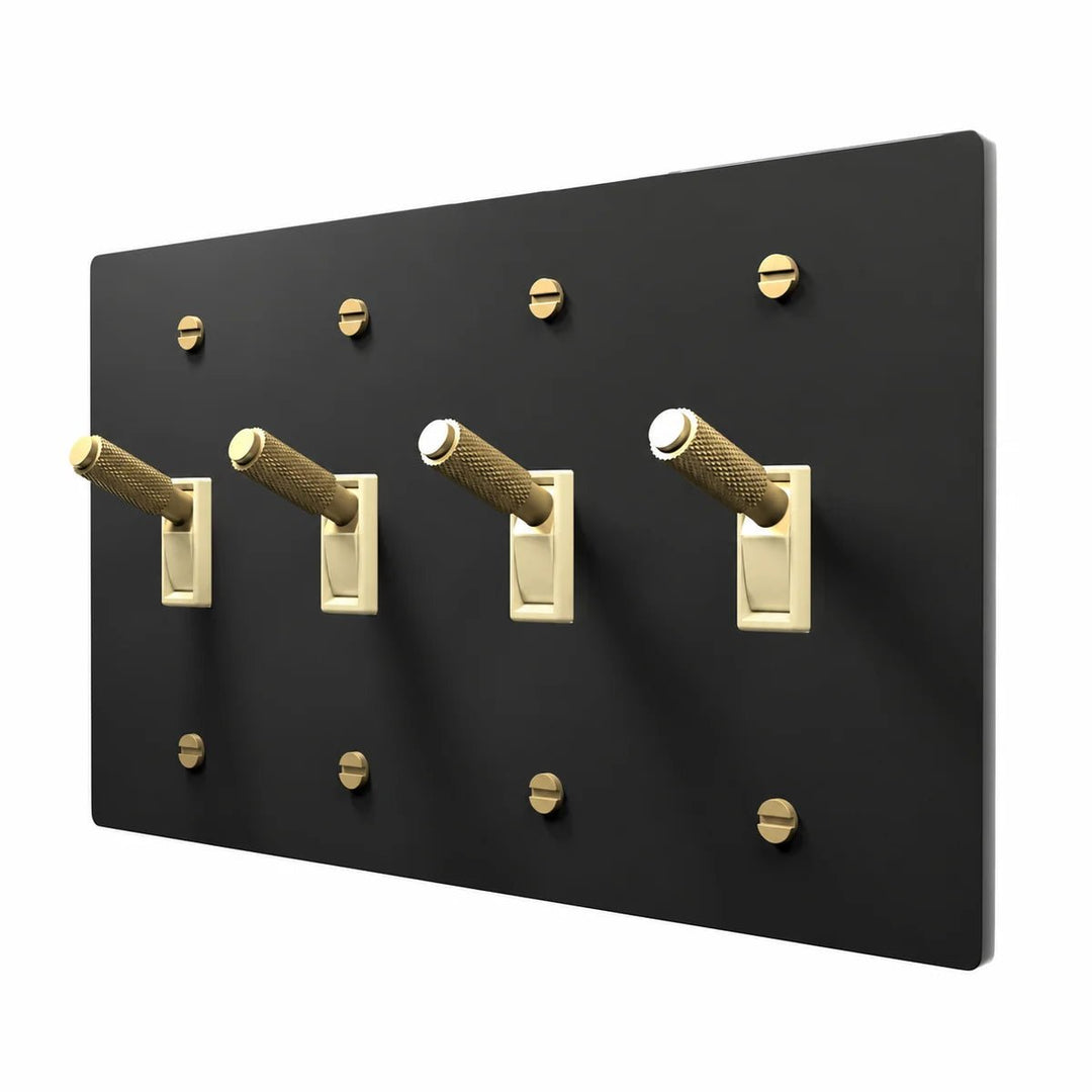 PlatePrestige Brass Toggle Switch 4-Gang in Black / Brass with ivory toggle frames, angled view