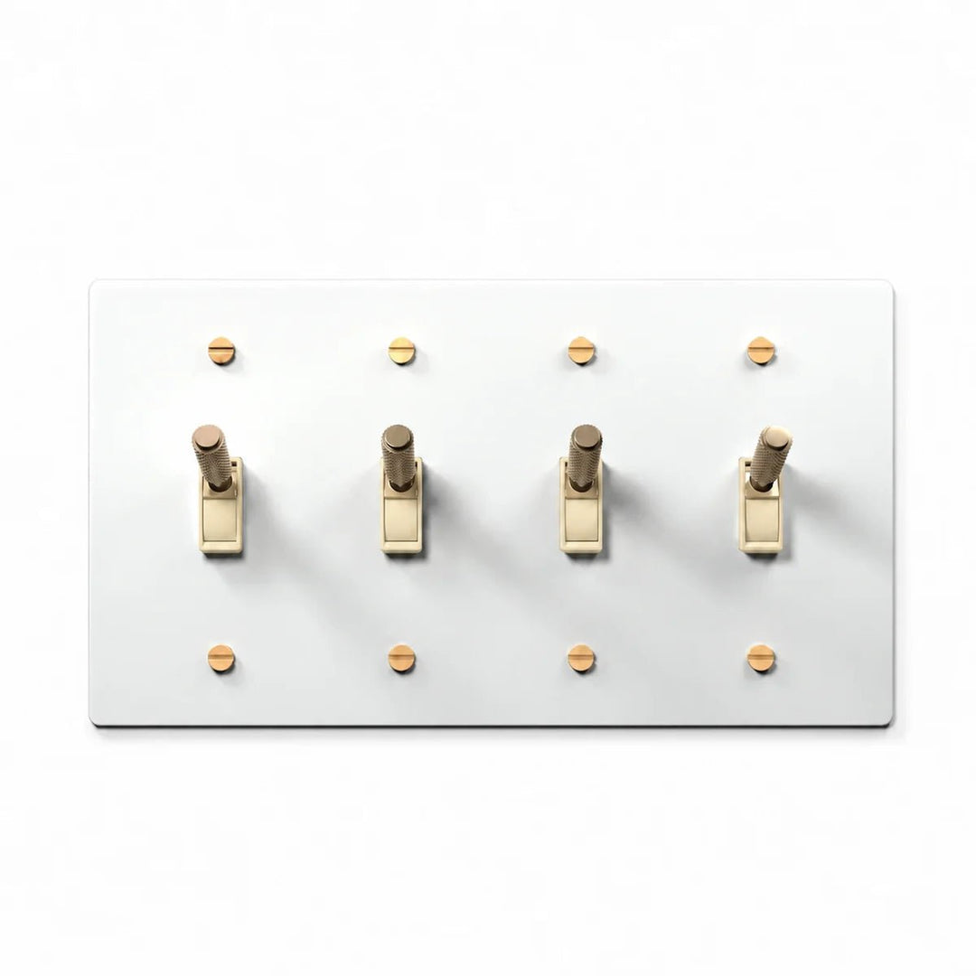 PlatePrestige Brass Toggle Switch 4-Gang in White / Brass with ivory toggle frames, angled view