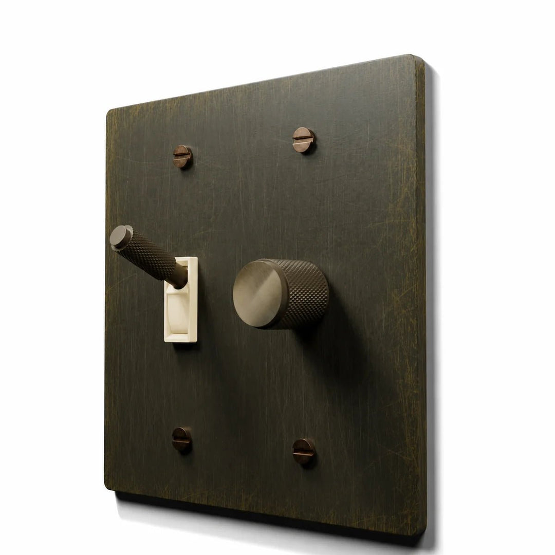 Brass Toggle & Dimmer Combo Switch Plate in Antique Brass with ivory toggle frames, angled view