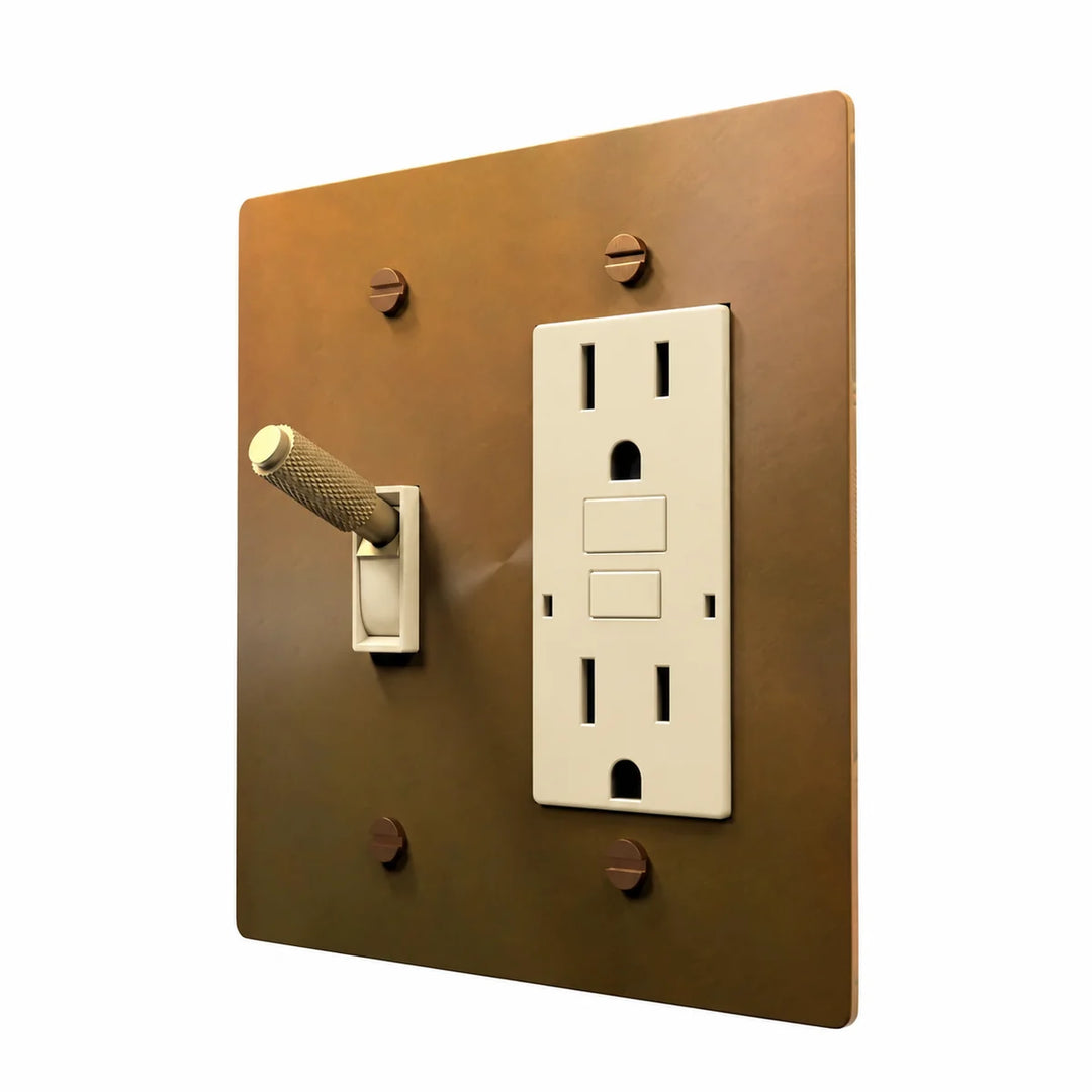 Brass Toggle & Outlet Combo Switch Plate in Unlacquered Aged brass with ivory toggle frames and outlet inserts, angled view