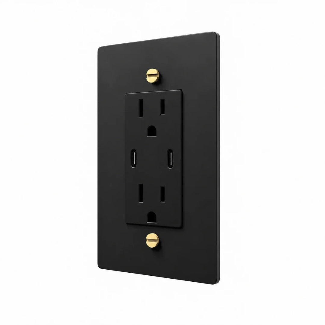 Angle view of PlatePrestige dual USB-C electrical outlet, black / brass wall plate with black receptacle and coordinated screws