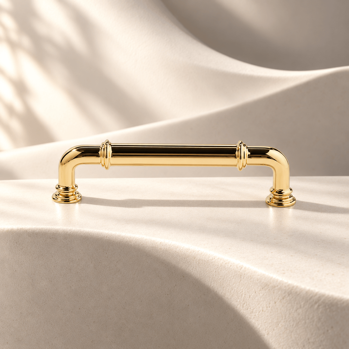 Polished gold 96 mm CTC curved cabinet pull on warm ivory stone