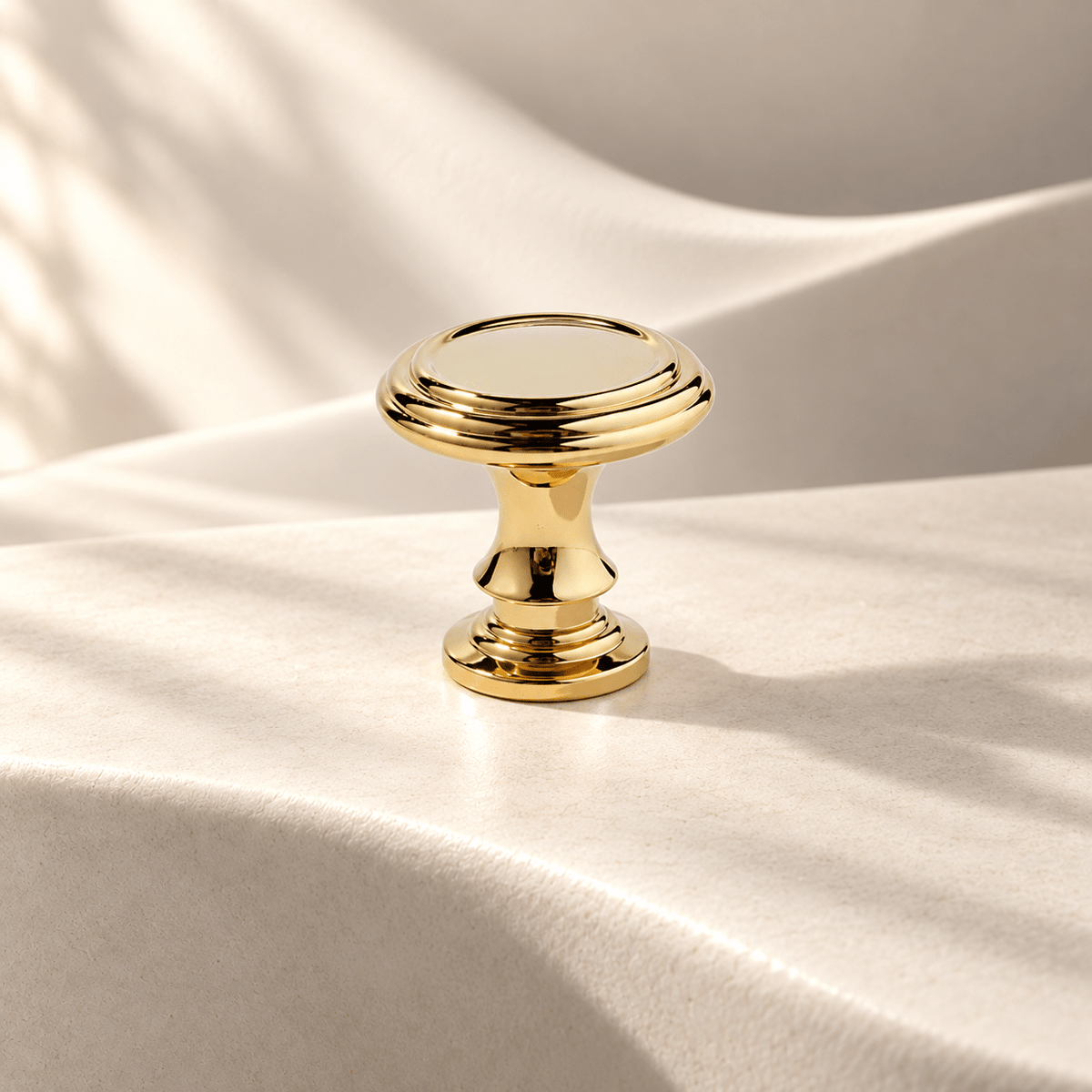 Polished gold 32 mm round cabinet knob on warm ivory stone