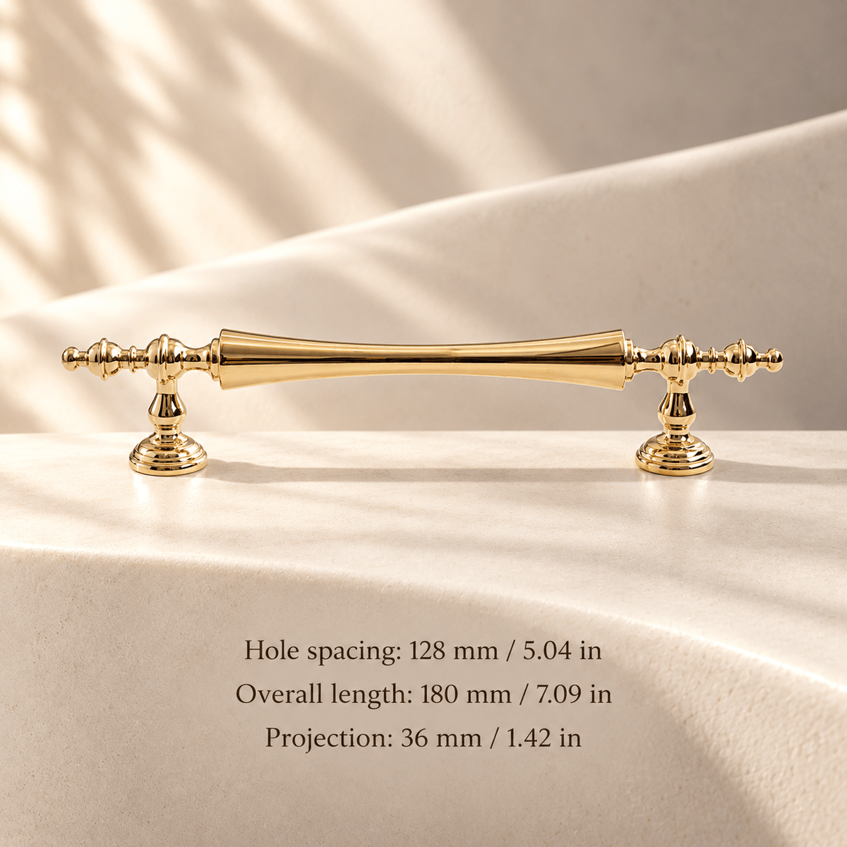 Polished gold ornate cabinet pull in ivory studio. Hole spacing: 128 mm / 5.04 in; Overall length: 180 mm / 7.09 in; Projection: 36 mm / 1.42 in