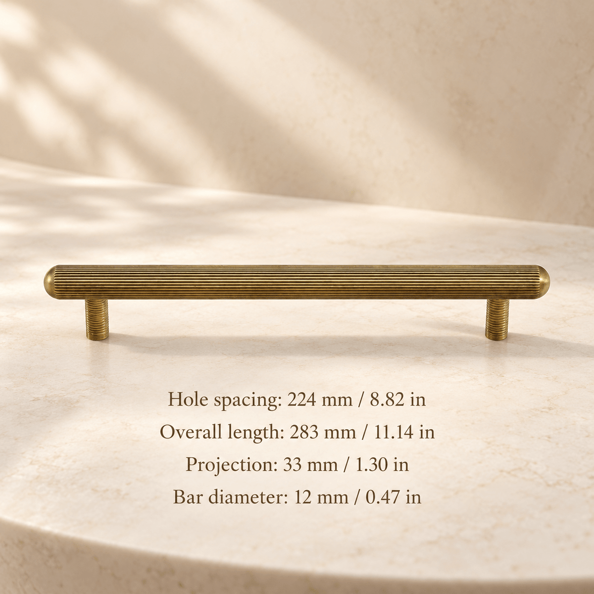Antique bronze ribbed capsule cabinet pull in ivory studio. Hole spacing: 224 mm / 8.82 in; Overall length: 283 mm / 11.14 in; Projection: 33 mm / 1.30 in; Bar diameter: 12 mm / 0.47 in