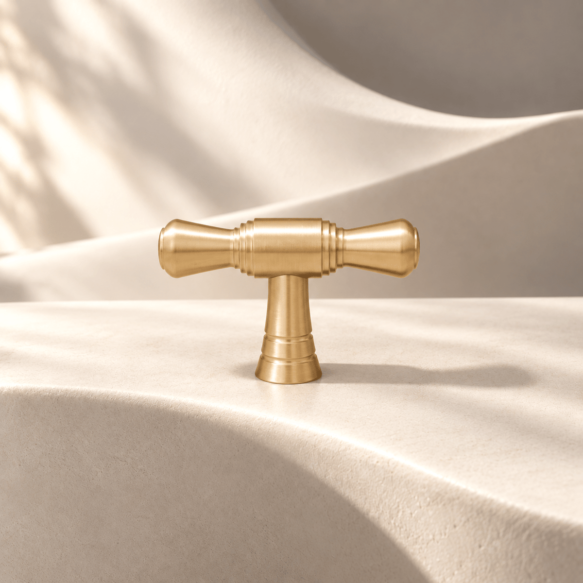 Satin gold 50 mm single-hole T-knob on warm ivory stone