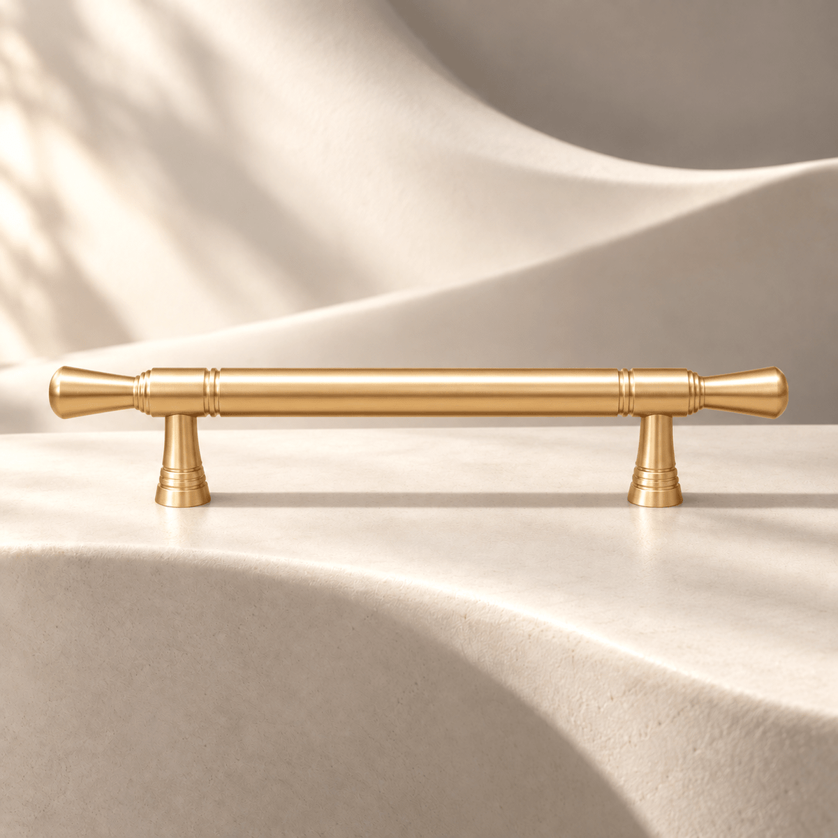 Satin gold 96 mm CTC cabinet pull on warm ivory stone