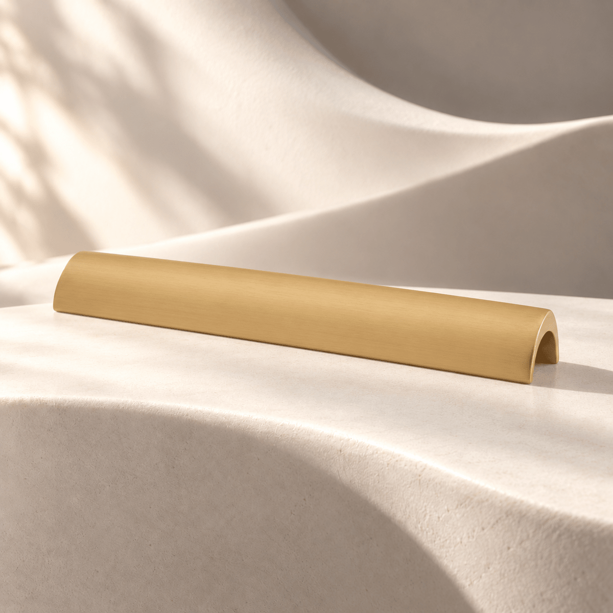 Satin gold curved cabinet pull, 128 mm hole spacing on ivory stone