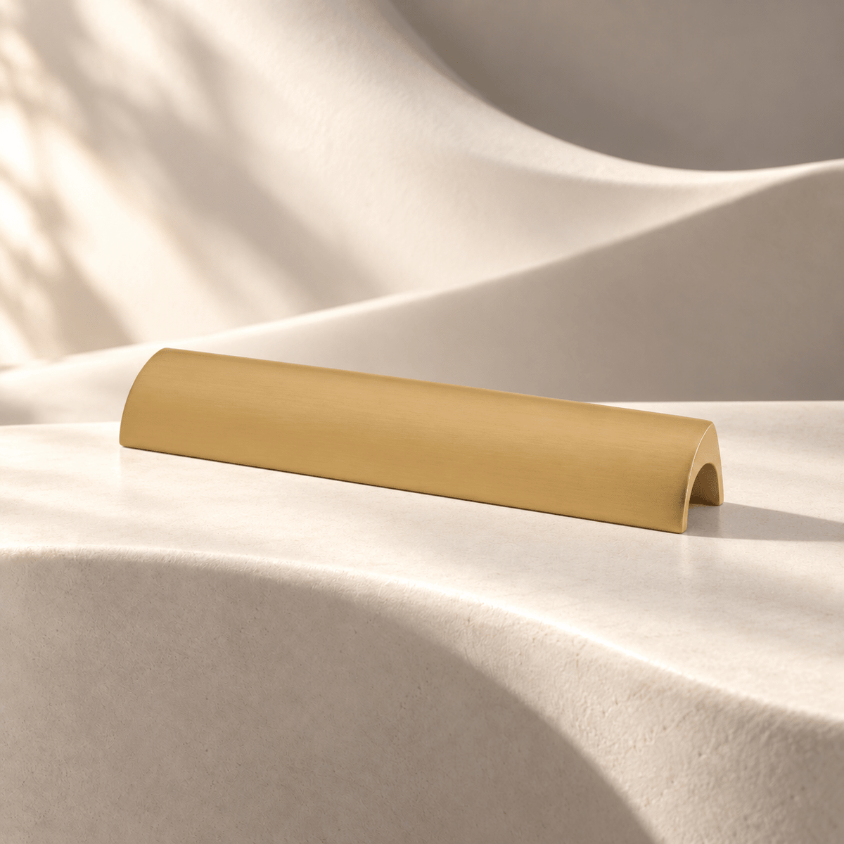 Satin gold curved cabinet pull, 96 mm hole spacing on ivory stone