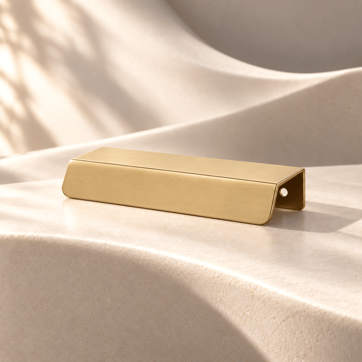 Satin gold 96 mm CTC cabinet edge pull on warm ivory stone