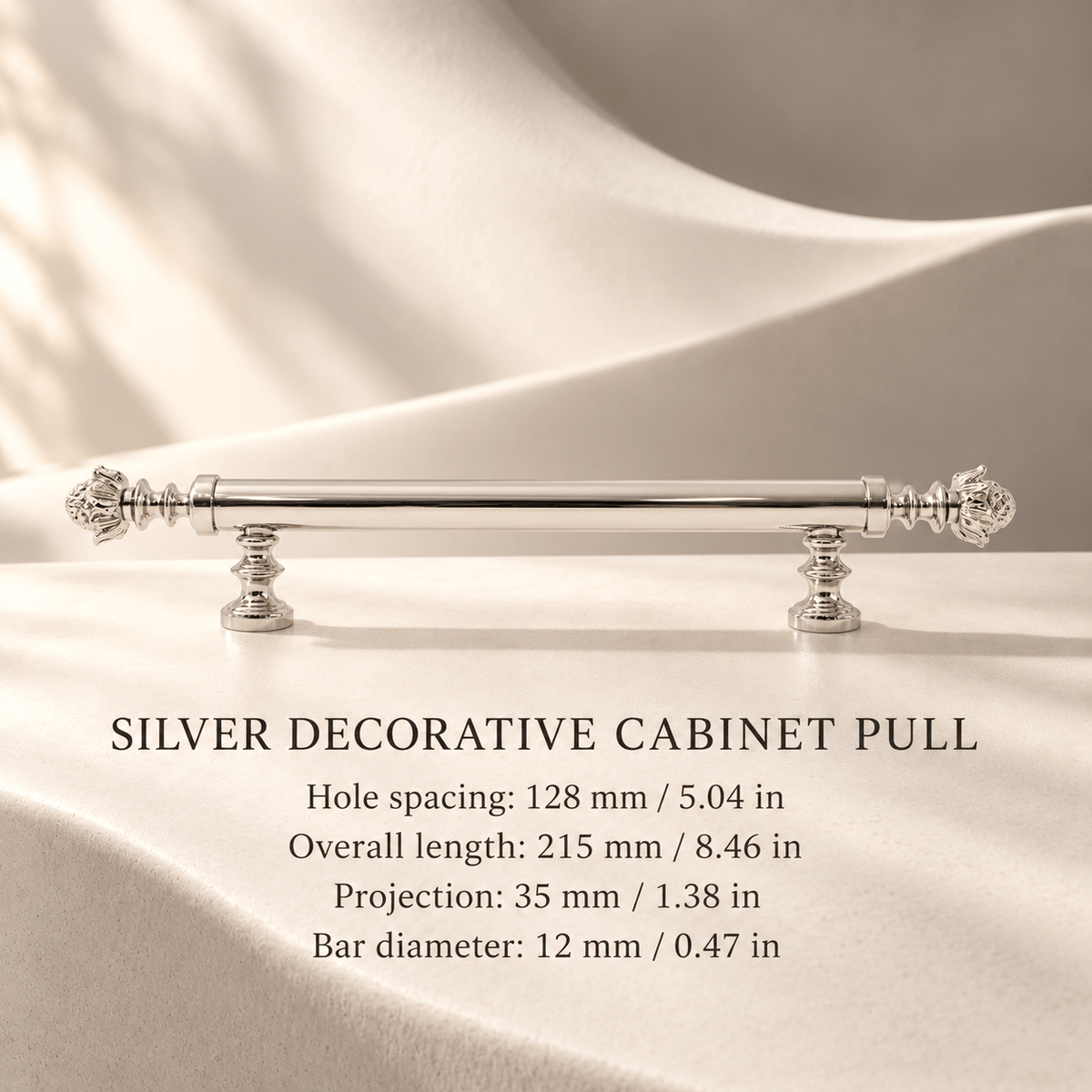 Silver decorative cabinet pull, 128 mm hole spacing, individual millimeter and inch dimensions in an ivory studio