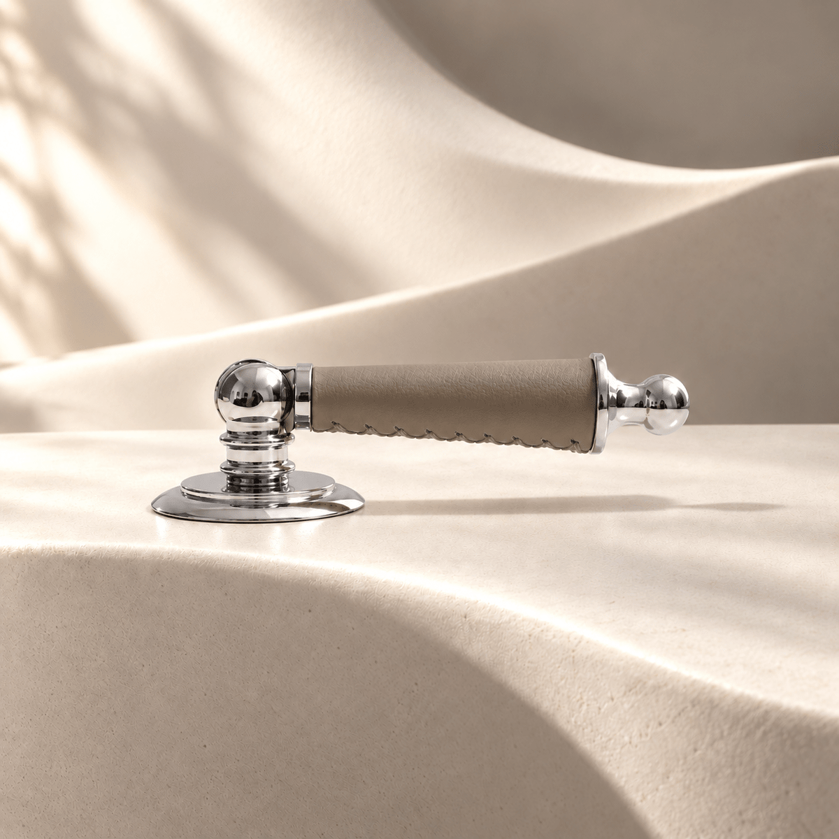 Silver-finish brass and gray leather drop pull on warm ivory stone